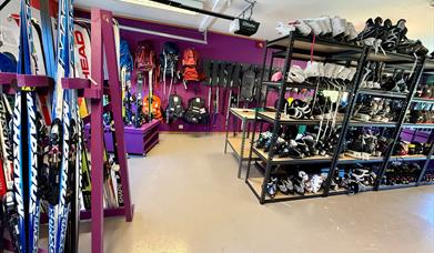 Innendørs utlånsrom hos BUA Audnedal med ski, skøyter, hjelmer, sekker og annet sports- og fritidsutstyr tilgjengelig for gratis utlån.