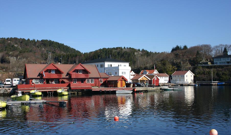Åvik Brygge, rødt bygning med gule båter ved brygga