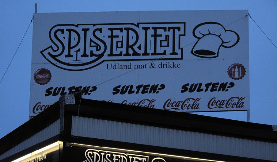 Svært skilt på taket "Spiseriet Udland mat & drikke"