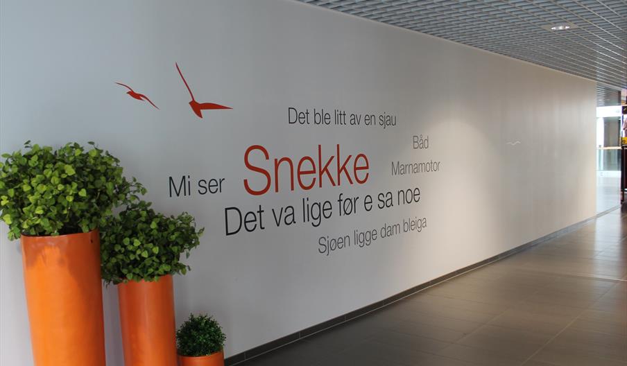 Vegg med ord på Mandalsdialekt på Alti senteret