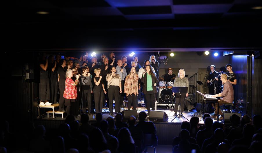 Byremo Gospelkor på scenen med fullt band, solister og korister under julekonserten på Byremo Scene.