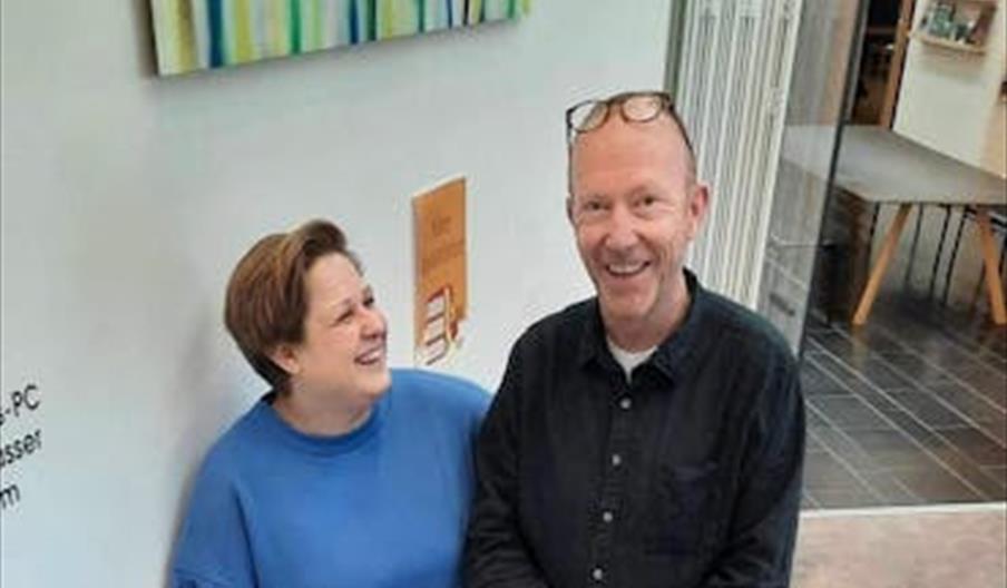 Miriam og Petter smilende sammen på biblioteket.