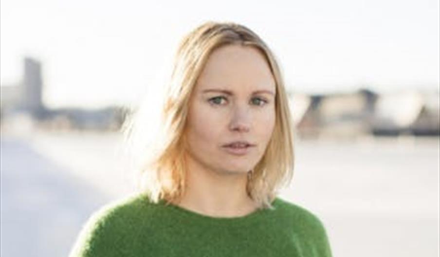 Portrett av forfatter Ida Gilbert i grønn genser utendørs.