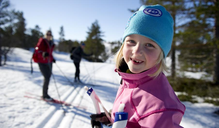 Jente på skitur i skogen, bilde