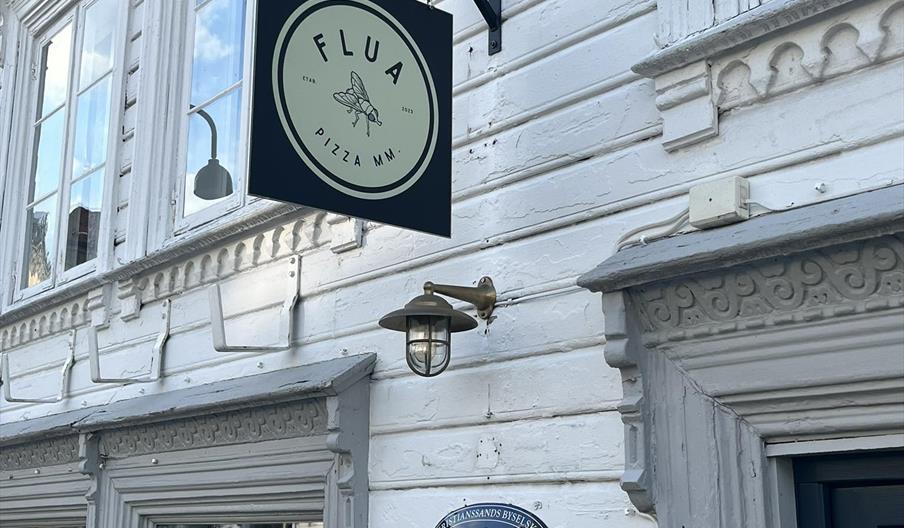 Skilt på utsiden av Flua Pizza