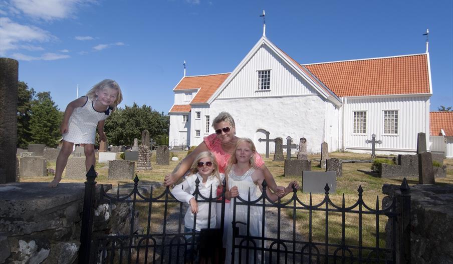 familie som står ved porten utenfor Tromøy kirke