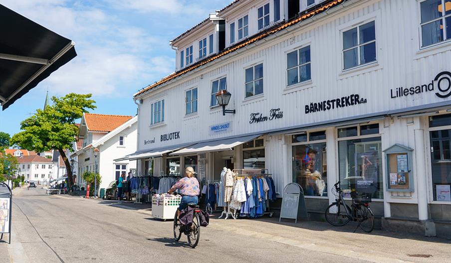 Kvinne som sykler i Lillesand sentrum