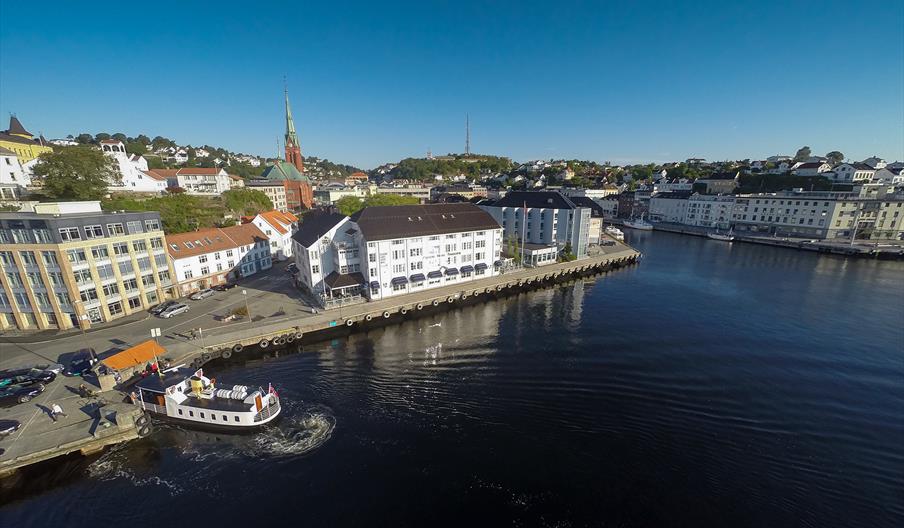 Clarion Hotel Tyholmen sett fra luften med fergeleiet på Tyholmen til venstre. Ferga Kolbjørn legger akkurat til kai.