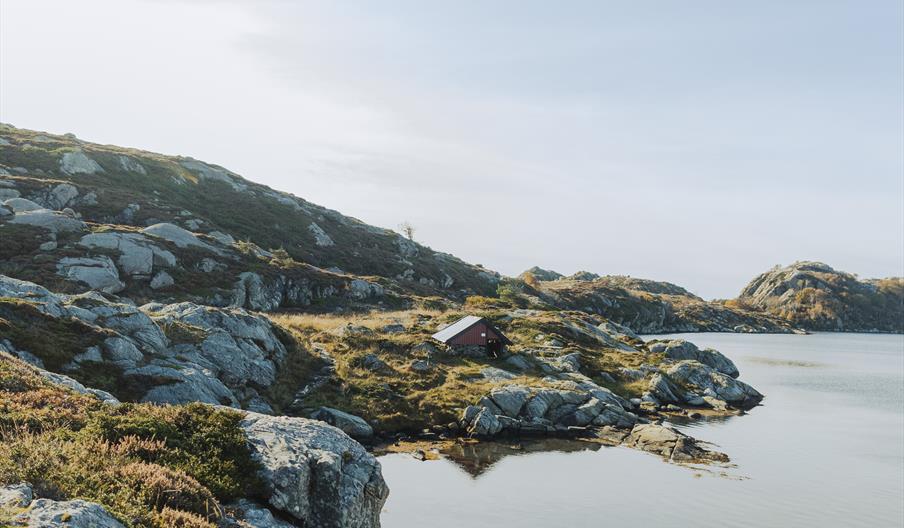 Turløype på Skjernøya rundt Rossnesvågen. Her er et lite skur helt nederst på fjellet i vannkanten