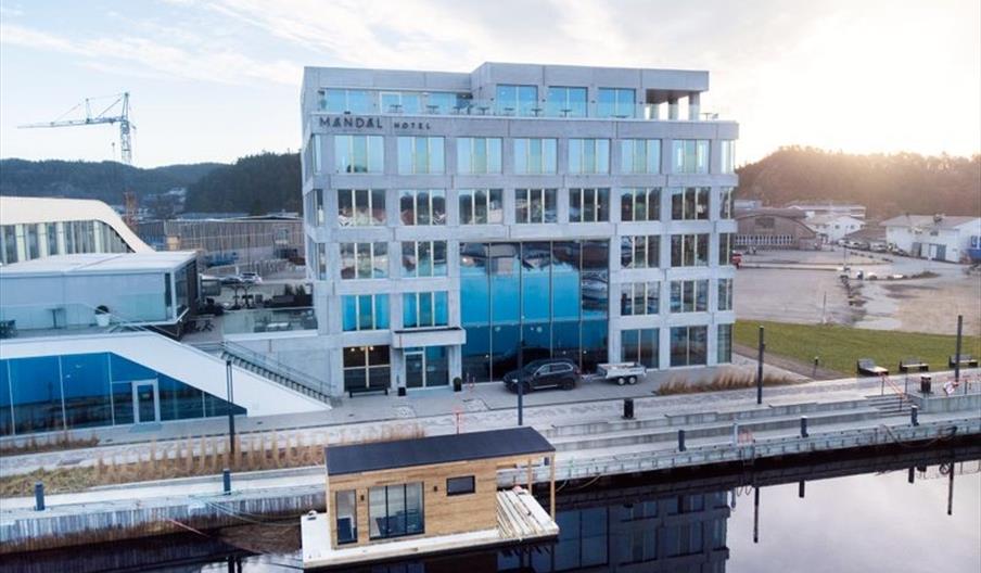 Oversiktsbilde av Mandal Hotel og badstubåten Pysen som ligger i Mandalselva