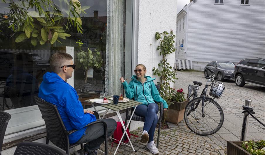 Et par som sitter å ha en pause fra sykkelturen, hos S.Kagestad kafe
