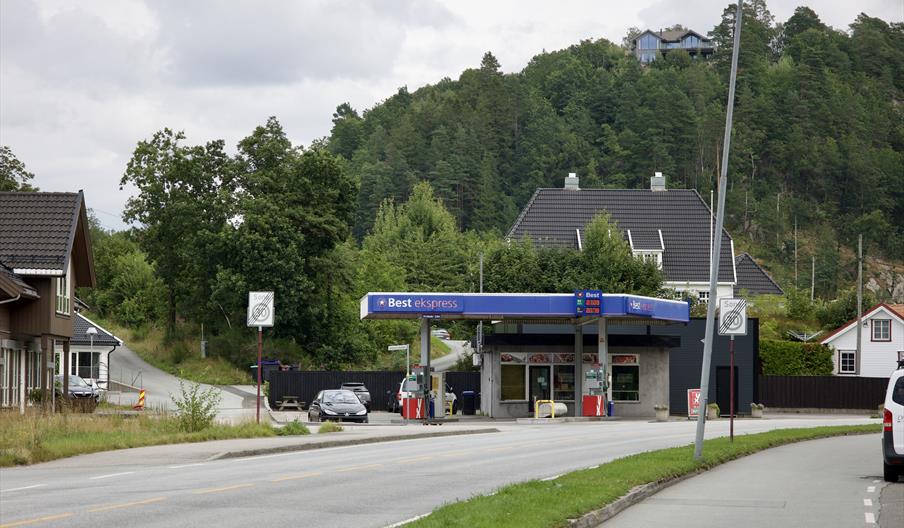 Best Ekspress bensinstasjon i Alleen, Lyngdal, med blått skilt og drivstoffpumper.