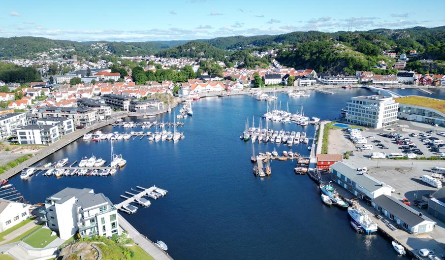 Dronebilde over Mandal gjestehavn, Mandalselva og Mandal by en solskinnsdag