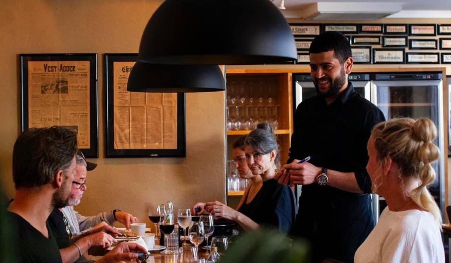 Servitør som serverer smilende gjester