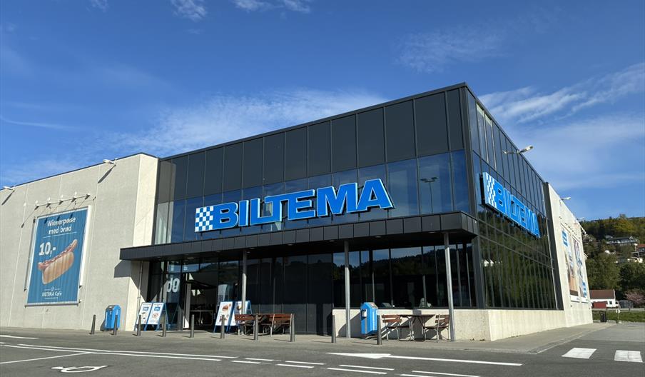 Fasaden til Biltema Lyngdal i Handelsparken, med blå logo og reklameskilt på veggen.