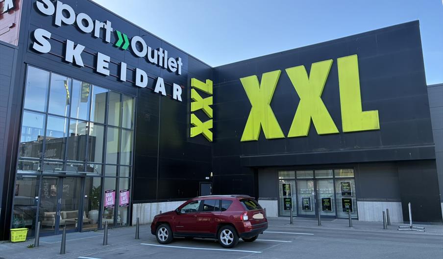 Inngangen til Skeidar Lyngdal i Handelsparken, med store vinduer og skilt.
