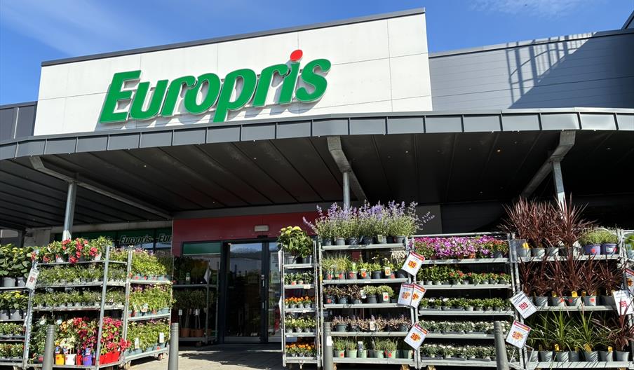 Inngangen til Europris i Handelsparken Lyngdal, med logo og handlevogner utenfor.