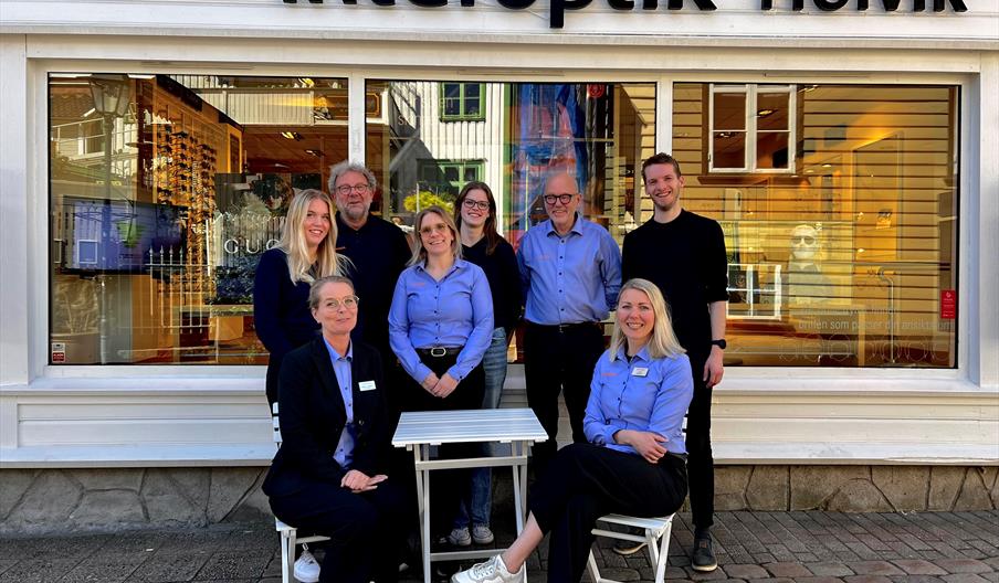 En gruppe av åtte ansatte utenfor Interoptik Holvik butikken