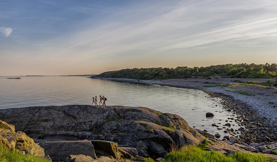 4 herrer på vei over svabergene i raet nasjonalpark ved Spornes strand på Tromøy utenfor Arendal for å ta morgenbad i mai.