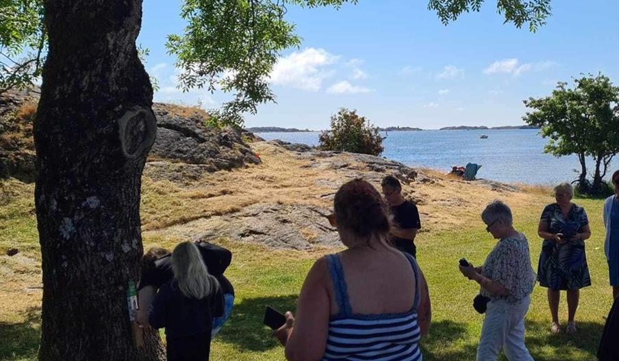 Folk ute i naturen ved siden av stolpen