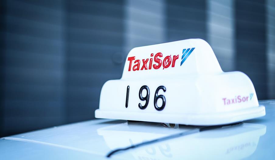 Nærbilde av Taxi Sør taxilampe på taket av en taxi.
