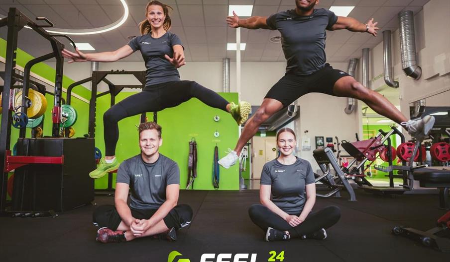 Treningsstudio, fire glade personer som poserer for kamera