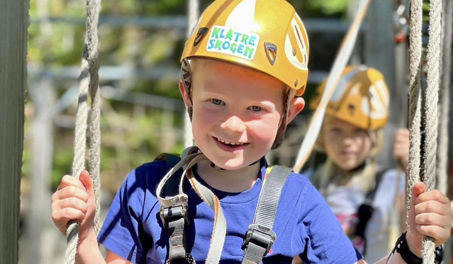 Smilende gutt i klatreskogen