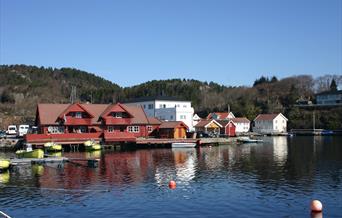 Åvik Brygge, rødt bygning med gule båter ved brygga