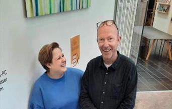 Miriam og Petter smilende sammen på biblioteket.