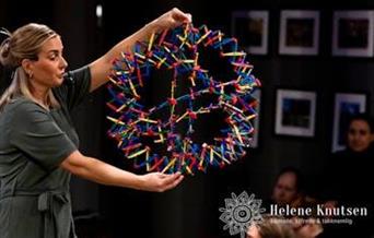 Helene Knutsen viser fram en stor fargerik konstruksjon under eventyrstunden.