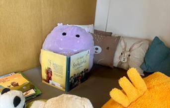 Kosedyr og puter i lesekroken på bibliotekets barneavdeling.