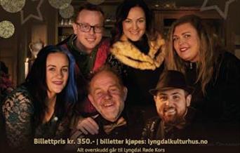 Gruppebilde av artistene bak Nissenes julekonsert, smilende i julepyntet miljø.