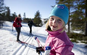 Jente på skitur i skogen, bilde