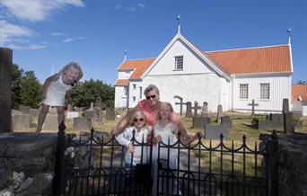 familie som står ved porten utenfor Tromøy kirke