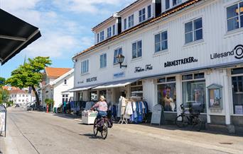 Kvinne som sykler i Lillesand sentrum