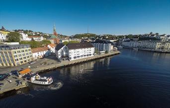 Clarion Hotel Tyholmen sett fra luften med fergeleiet på Tyholmen til venstre. Ferga Kolbjørn legger akkurat til kai.