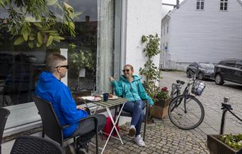 Et par som sitter å ha en pause fra sykkelturen, hos S.Kagestad kafe