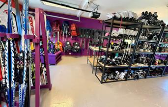 Innendørs utlånsrom hos BUA Audnedal med ski, skøyter, hjelmer, sekker og annet sports- og fritidsutstyr tilgjengelig for gratis utlån.