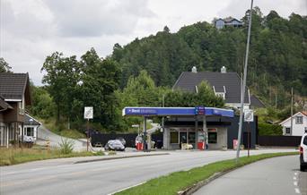 Best Ekspress bensinstasjon i Alleen, Lyngdal, med blått skilt og drivstoffpumper.