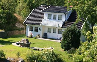 Strandhus Sandaa med fin gressplen i front