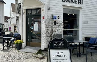 Fasade til Edgars bakeri i gågata i Mandal. Svære svarte bokstaver "BAKERI" på veggen.