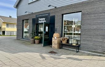 Fasade til butikken Happy homes med fine blomster på utsiden og åpen dør