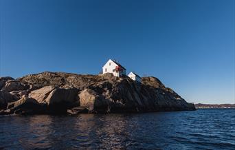 Utsikt inn fra havet og mot Hatholmen fyr