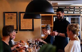 Servitør som serverer smilende gjester