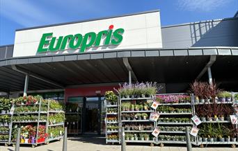 Inngangen til Europris i Handelsparken Lyngdal, med logo og handlevogner utenfor.