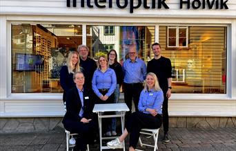 En gruppe av åtte ansatte utenfor Interoptik Holvik butikken