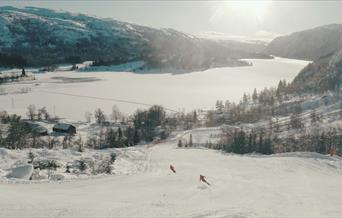 Skifører med fjellen som font , ljoslandskisenter, vinter