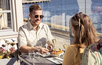 et par på utesrestaurnat i sjøkanten på Clarion Hotel Tyholmen