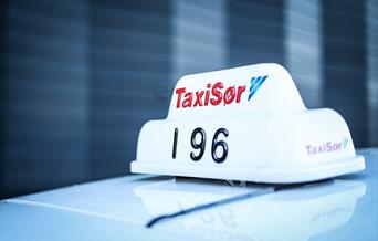 Nærbilde av Taxi Sør taxilampe på taket av en taxi.