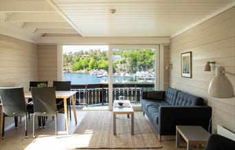 stue med sofa og spisebord og utsikt til sjøen